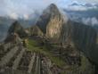 As the sun rises over the mountains to shine on Machu Picchu