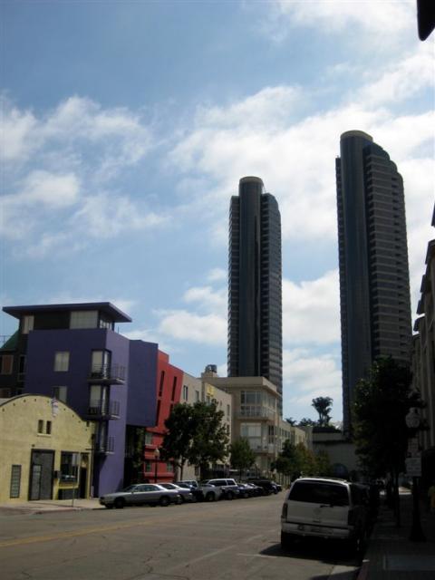 Colourful building with highrises beside